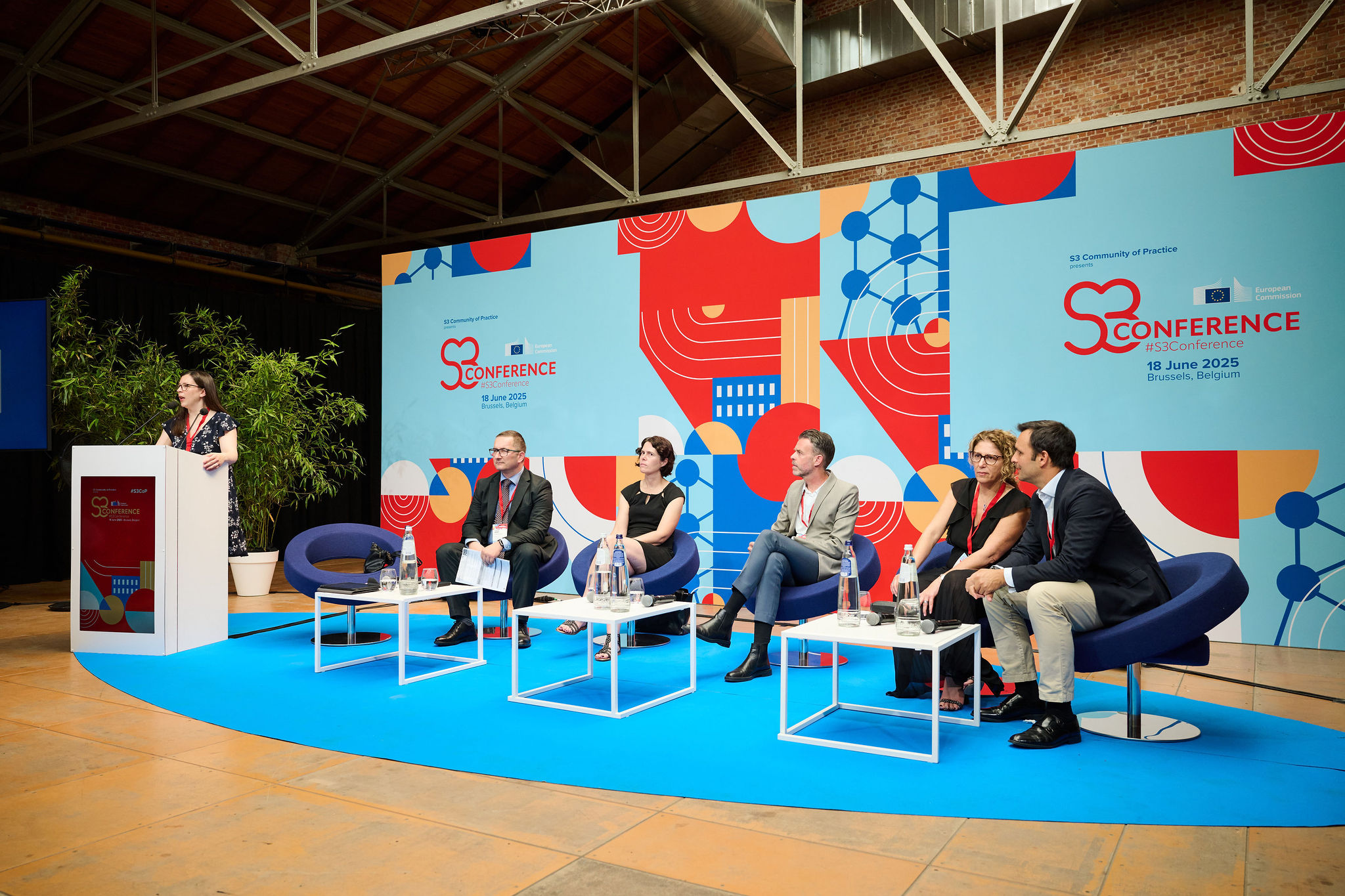 Panel discussion on stage at the S3 Conference 2025 in Brussels, with six speakers seated, in front of a large branded backdrop featuring the S3 Conference visual identity.